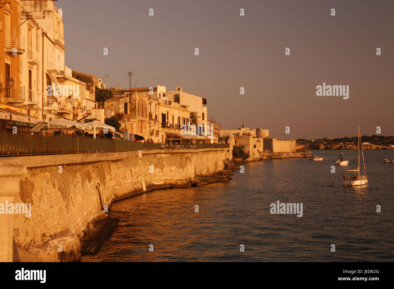 L'Italia, Sicilia, isola di Ortigia, Siracusa, banca promenade, street cafe, mare, barche da pesca, tramonto, Europa meridionale, Siracusa, promenade, case, edifici, mare, barche, destinazione, turismo, estate, sole di sera, luce della sera, ottimizzazione Foto Stock