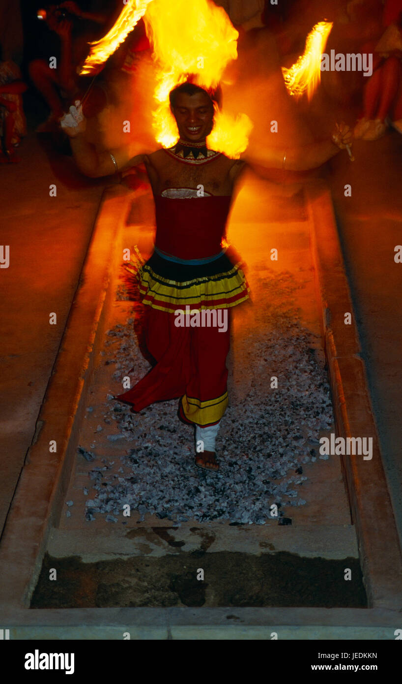 Sri Lanka, Kandy, giovane uomo prendendo parte a camminare sul fuoco cerimonia camminare a piedi scalzi su carboni ardenti che trasportano razzi luminosi. Foto Stock