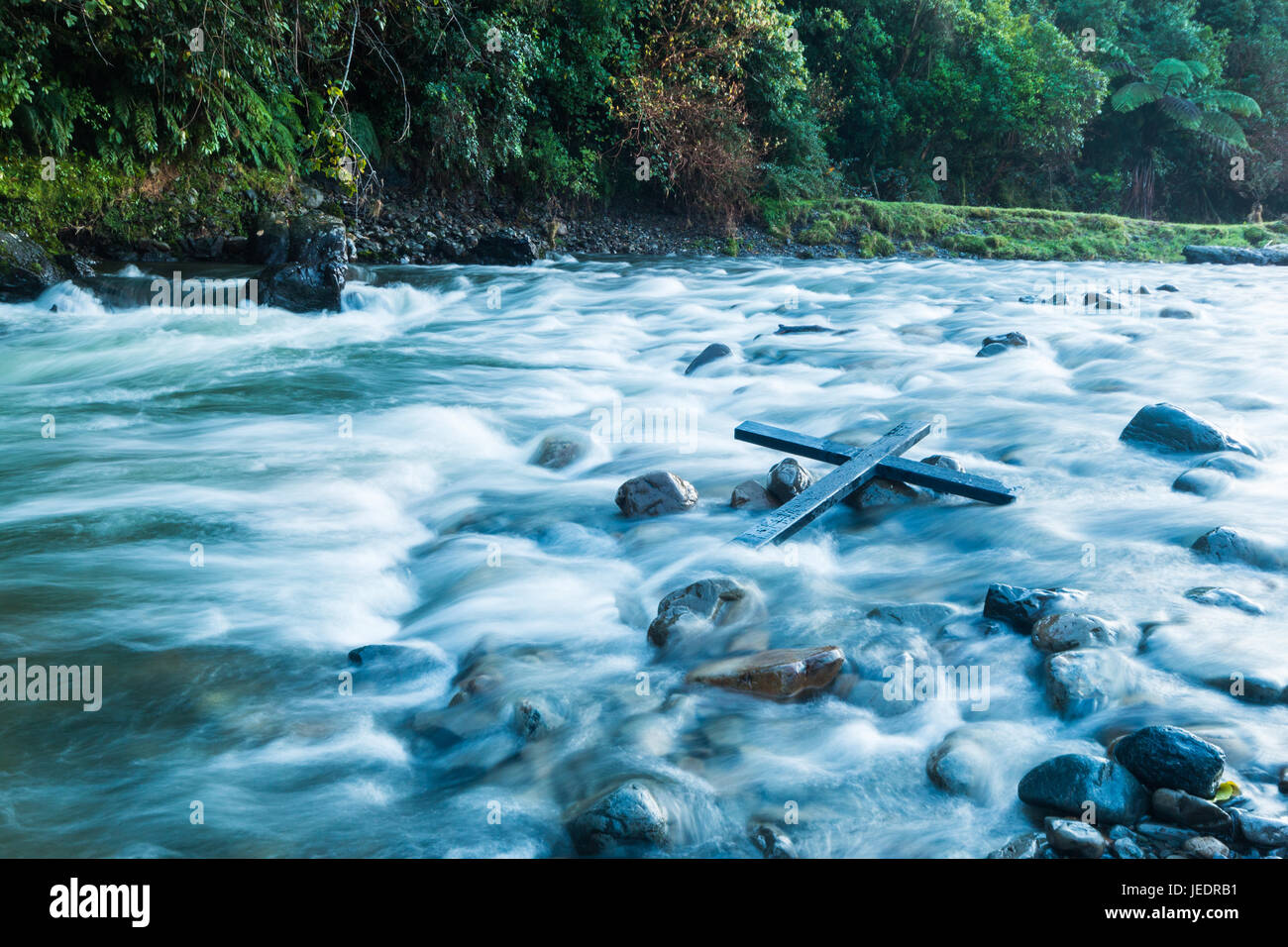 Nero croce di legno in alcuni white water rapids Foto Stock