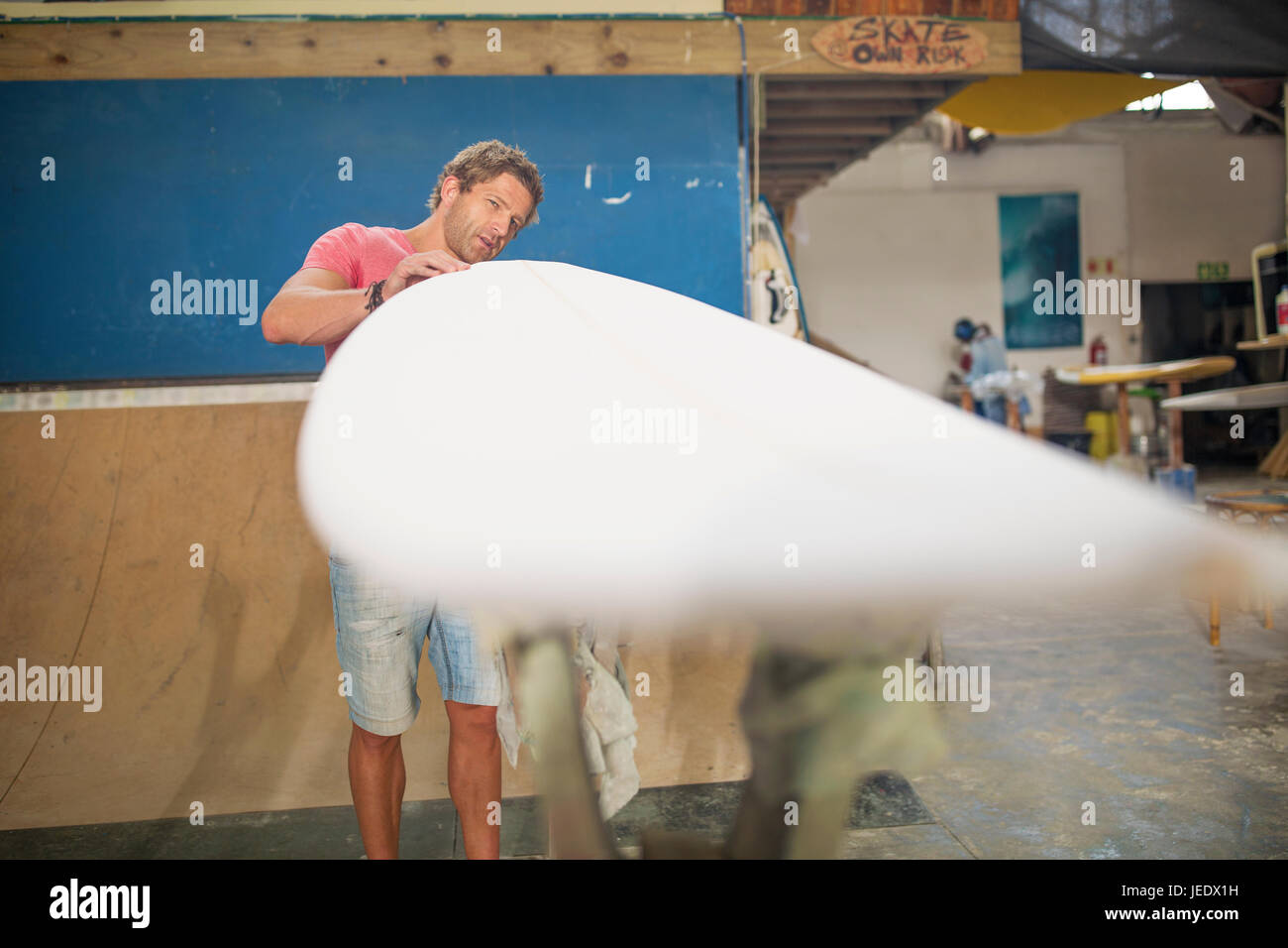 Tavola da surf shaper workshop, uomo controllare le tavole da surf Foto Stock