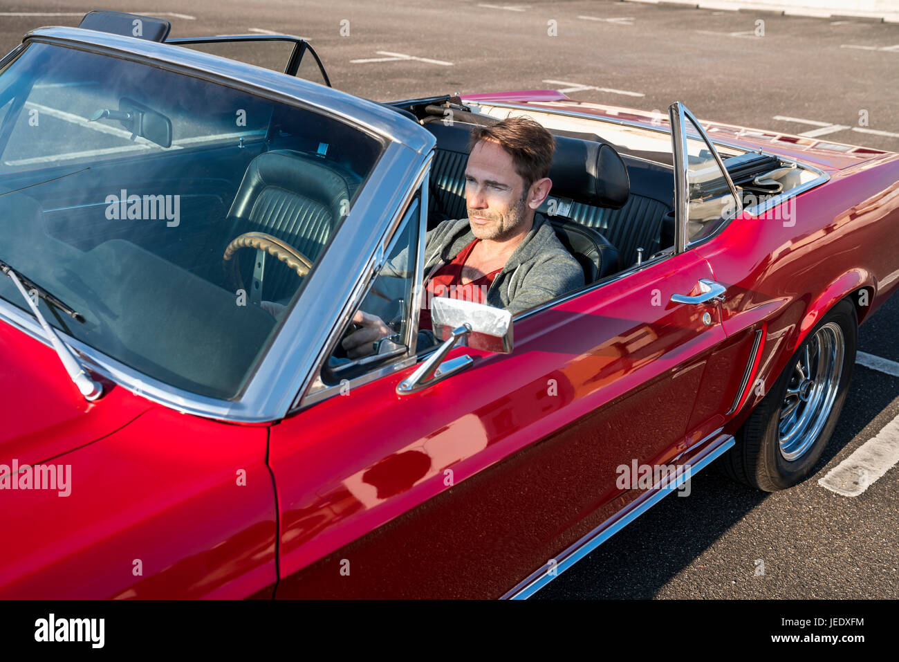 Coppia uomo seduto nella sua auto sportiva rossa Foto Stock