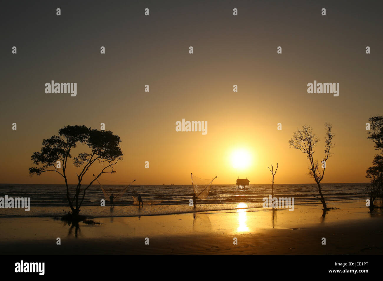 Pescatore sulla spiaggia golden sunrise Tan Thanh beach Go Cong Viet Nam atmosfera romantica silhouette nera Foto Stock