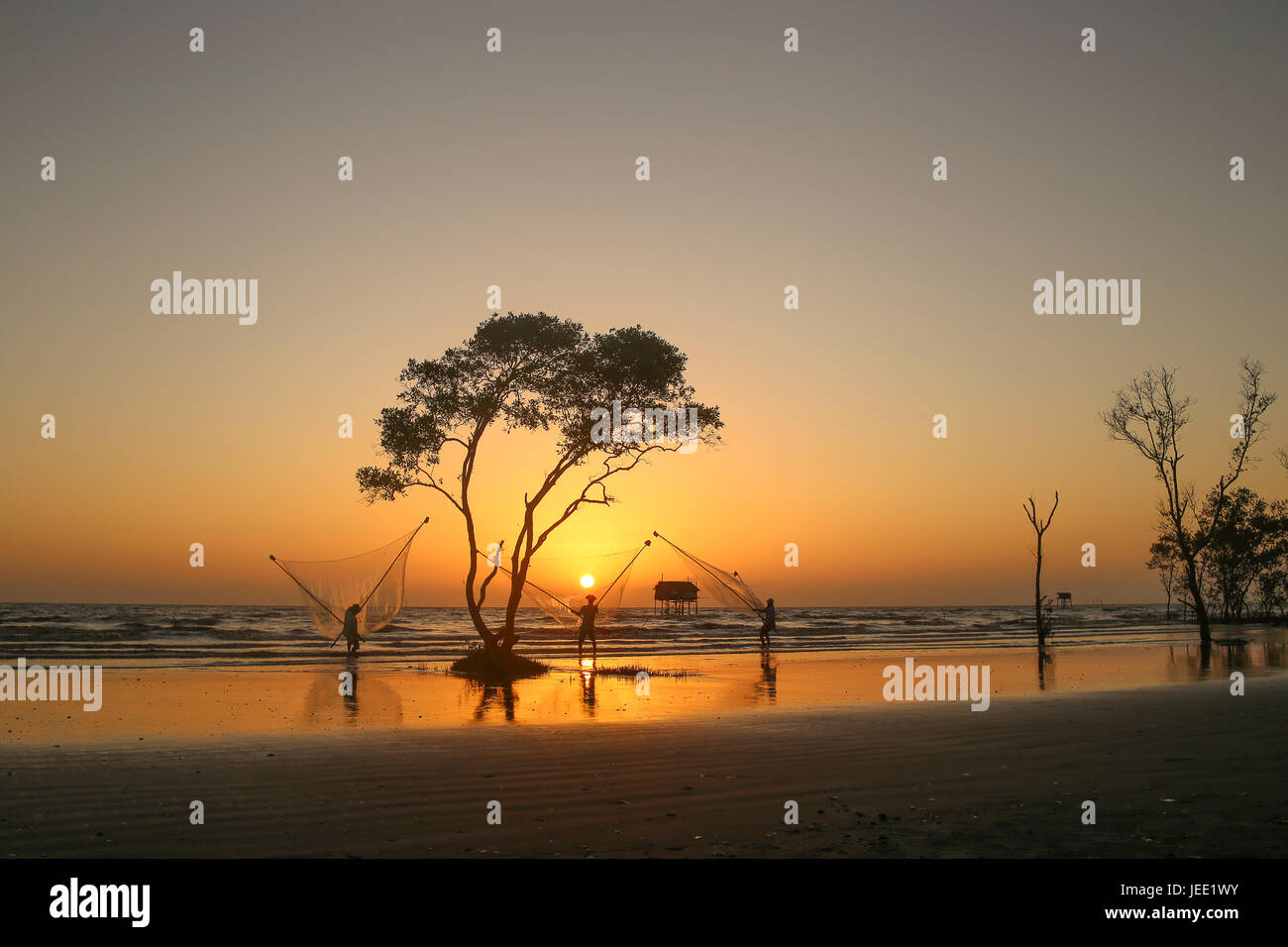 Pescatore sulla spiaggia golden sunrise Tan Thanh beach Go Cong Viet Nam atmosfera romantica silhouette nera Foto Stock
