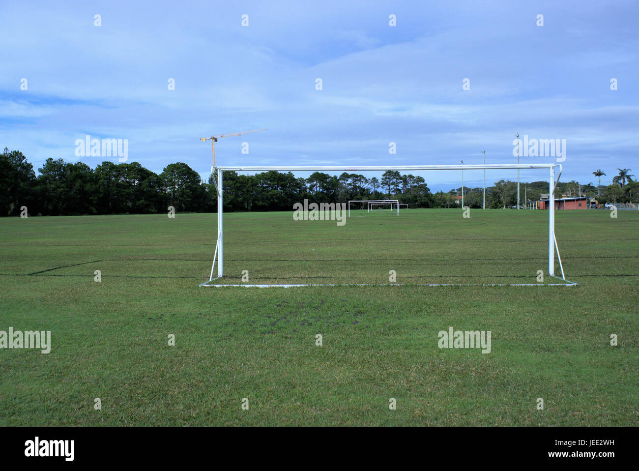 Parco giochi di calcio in Australia. Parco giochi di calcio con pali, proiettori, alberi e una gru in lontananza. Foto Stock