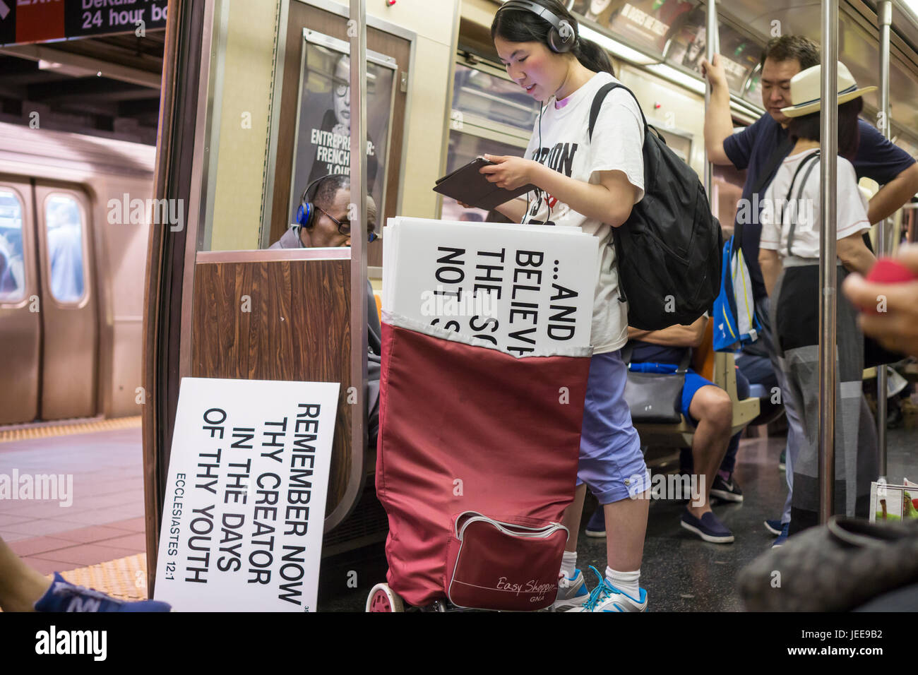 Un asiatico chiesa evangelica stati viaggi sulla metropolitana di New York con i suoi segni di Domenica, 18 giugno 2017. (© Richard B. Levine) Foto Stock