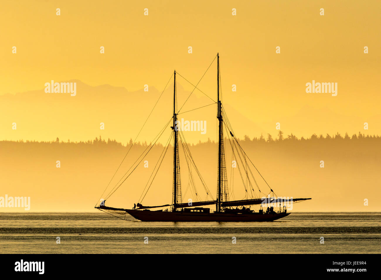 Barca a vela, barca a vela goletta in legno yacht vicino a Port Townsend, Puget Sound, Washington con sunrise e Cascade Mountains. Barca a vela Adventuress. Foto Stock