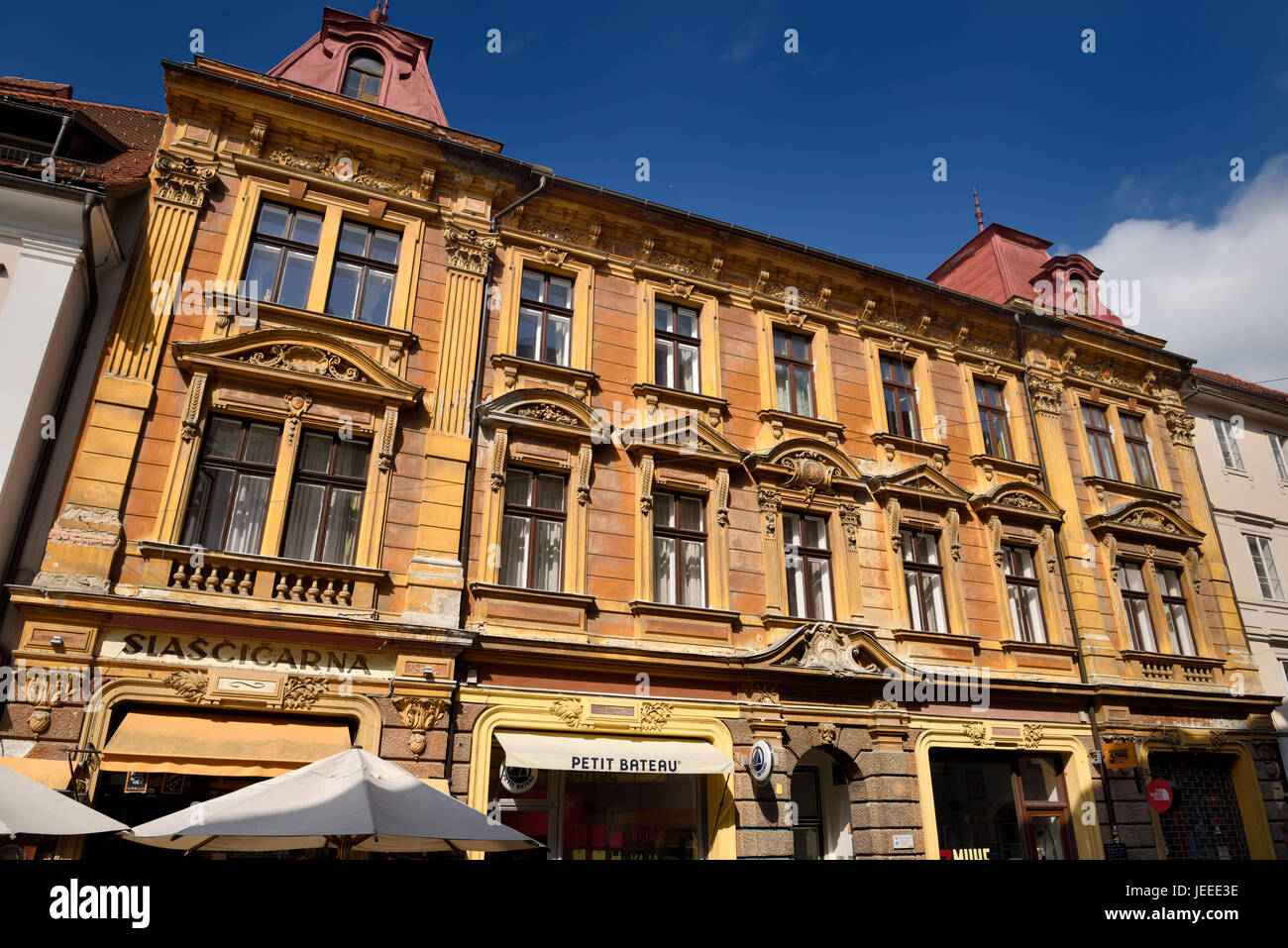 Color oro edificio storico costruito 1898 sulla Piazza Vecchia Stari trg con negozi di via Ljubljana Slovenia con cielo blu Foto Stock
