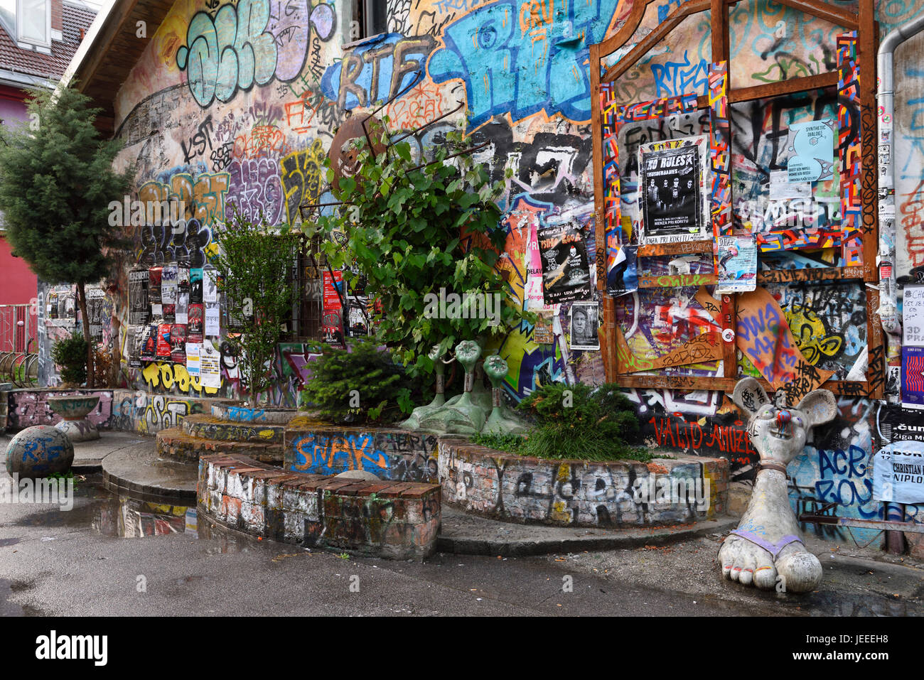 Graffiti e sculture a Metelkova City autonomo centro culturale squat alla ex Repubblica iugoslava di Esercito Nazionale caserma militare di Lubiana in Slovenia Foto Stock