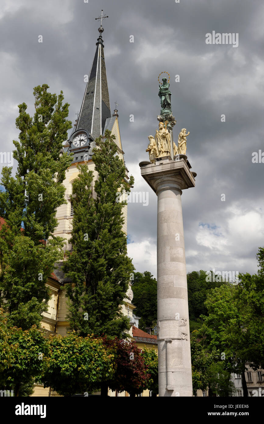 Orologio e il campanile di St James parrocchia cattolica e Chiesa di Santa Maria della Colonna della vergine in ottone e statue in pietra di santi Ljubljana Slovenia Foto Stock