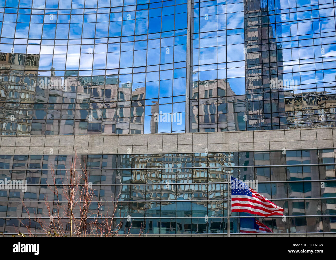 Bandiera americana e il pennone di fronte alto e moderno edificio di vetro con il grattacielo riflessioni, il centro di Boston, Massachusetts, STATI UNITI D'AMERICA Foto Stock