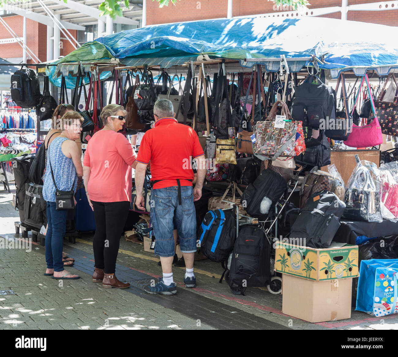 Fornitore a parlare con i potenziali clienti in un sacchetto in stallo il Bullring Mercato nel centro di Birmingham, Inghilterra, Regno Unito Foto Stock