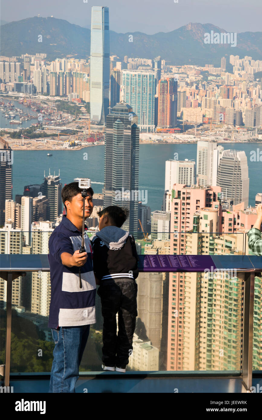 Vista verticale di un uomo prendendo un selfie dal fino al picco di Hong Kong, Cina. Foto Stock