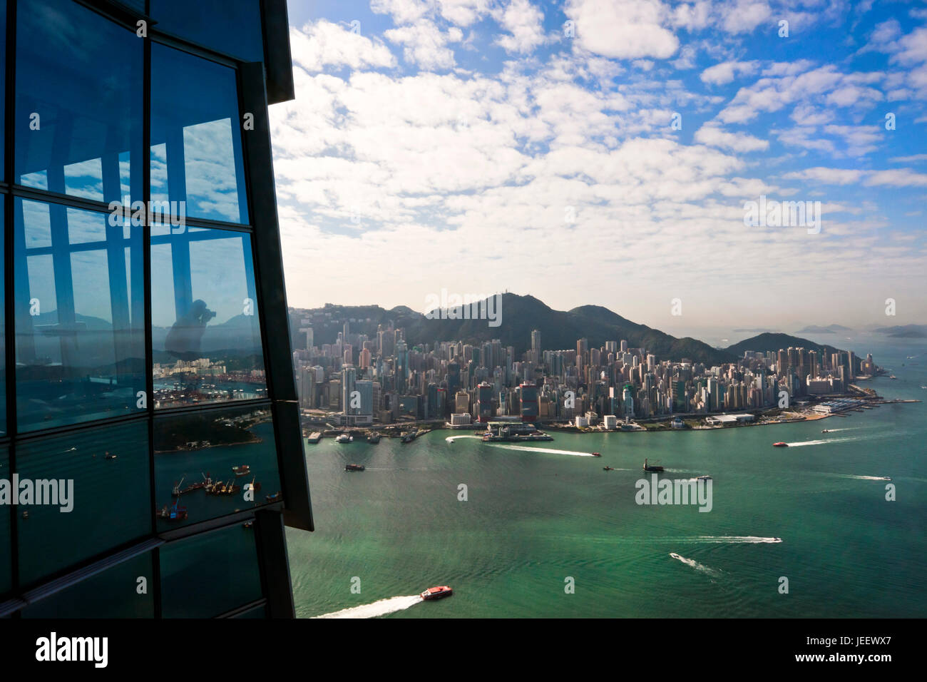 Vista orizzontale di un turista di scattare le foto dal cielo100 piattaforma di osservazione presso l'International Commerce Centre di Hong Kong, Cina. Foto Stock