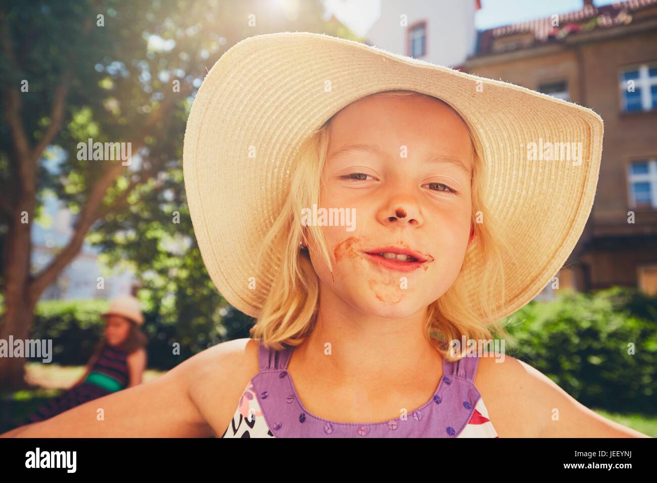 Giorno d'estate in città. Bambina con una bocca sporca dopo mangiare il gelato. Foto Stock