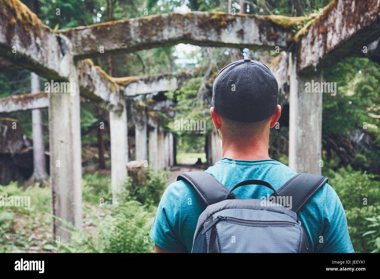 Young Explorer all'interno dell'abbandonato vecchio rovinato la fabbrica in mezzo alla foresta. Monti Metalliferi, Repubblica Ceca Foto Stock
