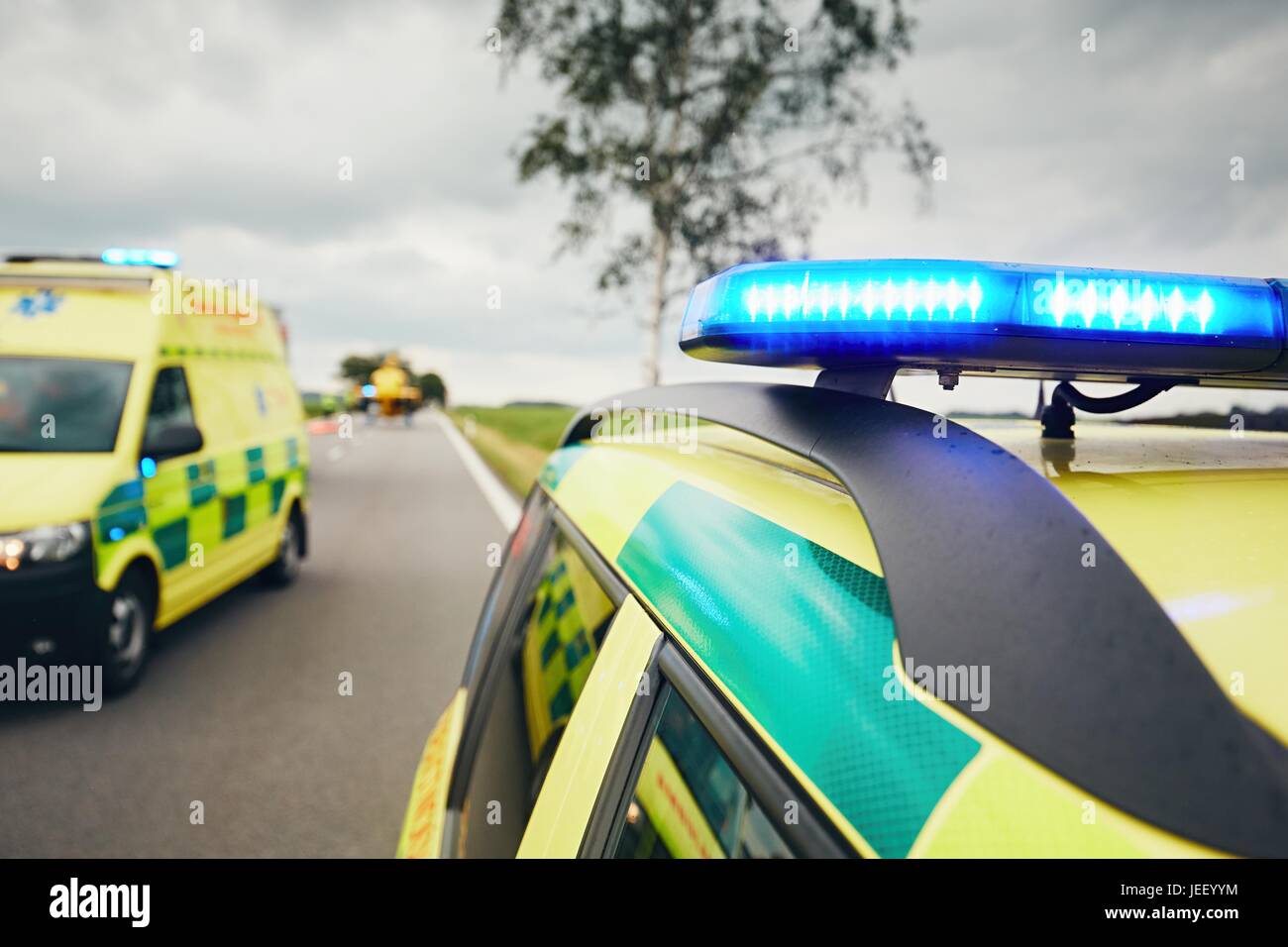 Ambulanze. Team del servizio medico di pronto soccorso sono la risposta a un incidente stradale in cattive condizioni atmosferiche. Foto Stock