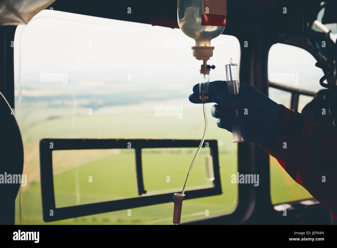 Silhouette della mano del medico e infusione. Elicottero del servizio di emergenza medica in volo. Repubblica ceca Foto Stock