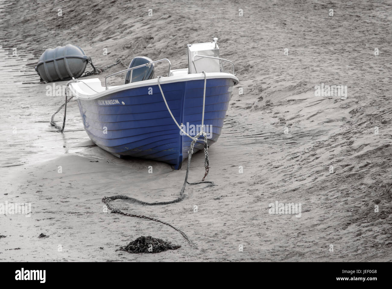 Una barca blu nella sabbia sulla spiaggia, colore selettivo Foto Stock