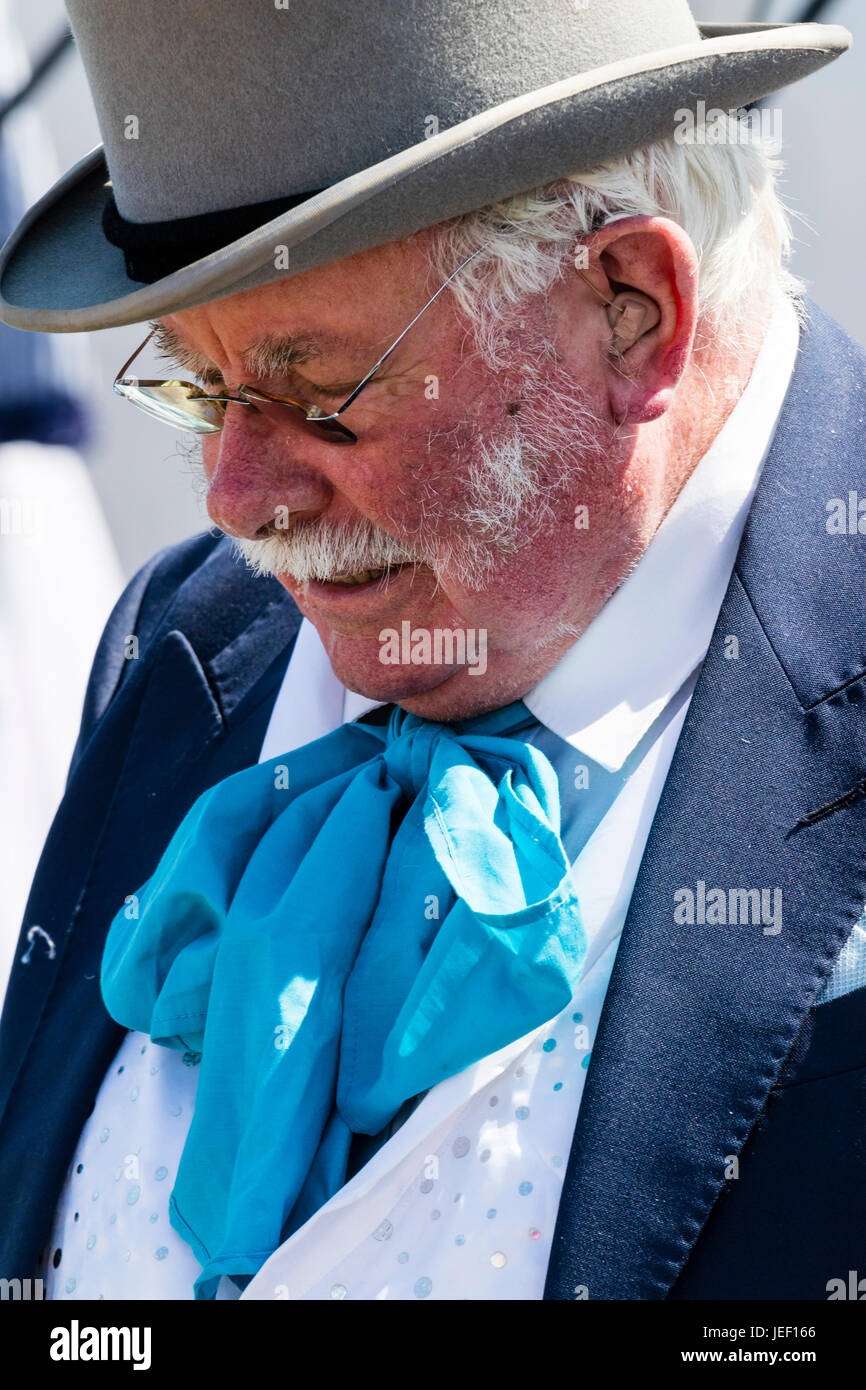 Ritratto di classe superiore senior uomo, 50s, con i baffi, lato burns e indossa gli occhiali. Vestito in costume Vittoriano, cravat blu e grigio top hat. Foto Stock