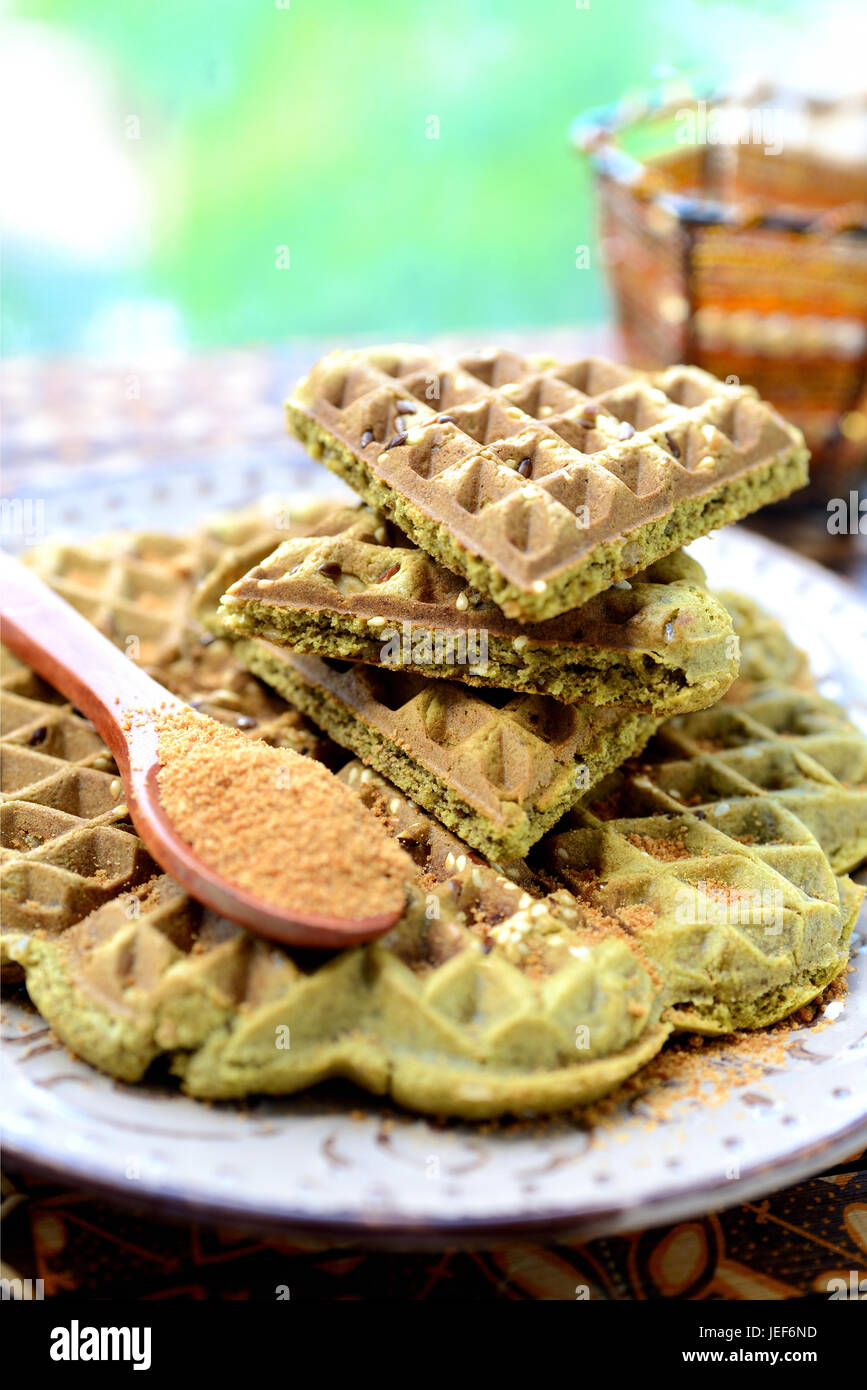 Waffles fatti in casa con aggiunta di matcha, pistacchi semi di lino. Decorata con zucchero di cocco. Foto Stock