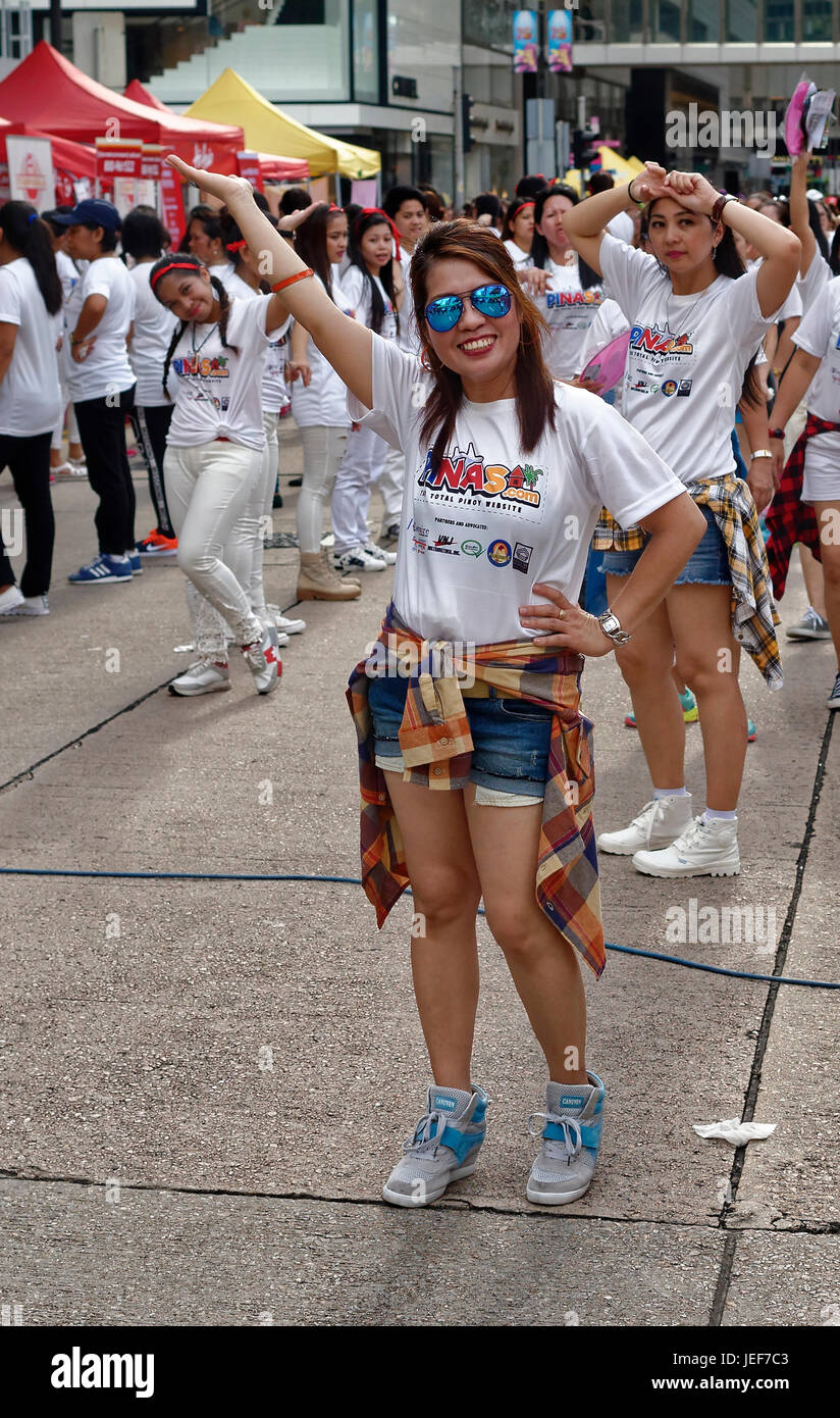 Lavoratori filippini a Hong Kong creare una massiccia line dance per le strade del centro. Foto Stock