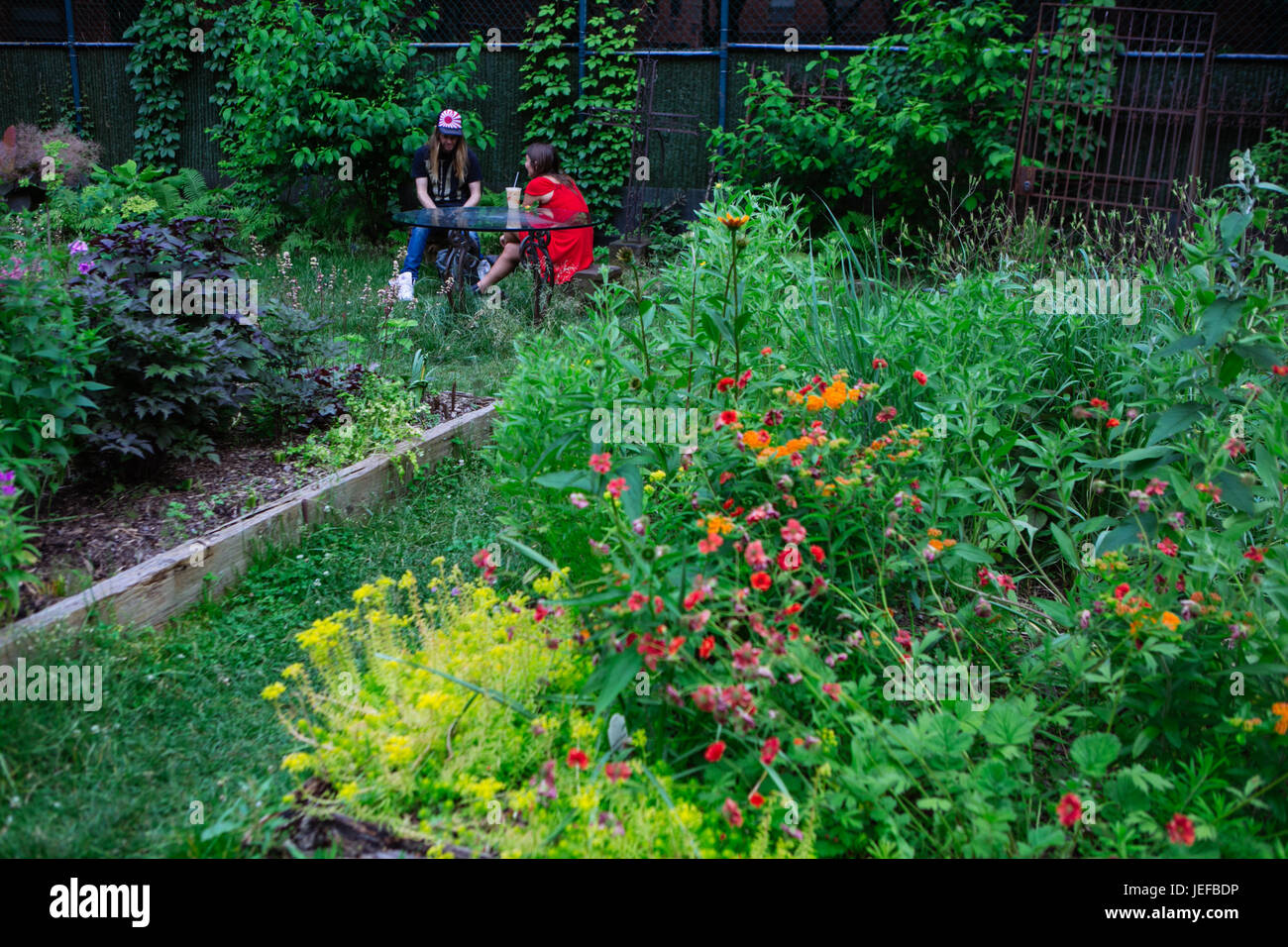 Un giovane seduto su una panchina in Elizabeth Street Garden, Manhattan, New York City, Stati Uniti d'America Foto Stock