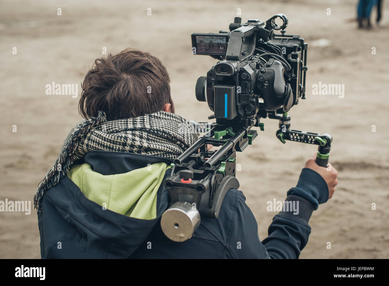 Dietro la scena. Cameraman per le riprese dei film scena con la sua fotocamera sulla posizione esterna Foto Stock