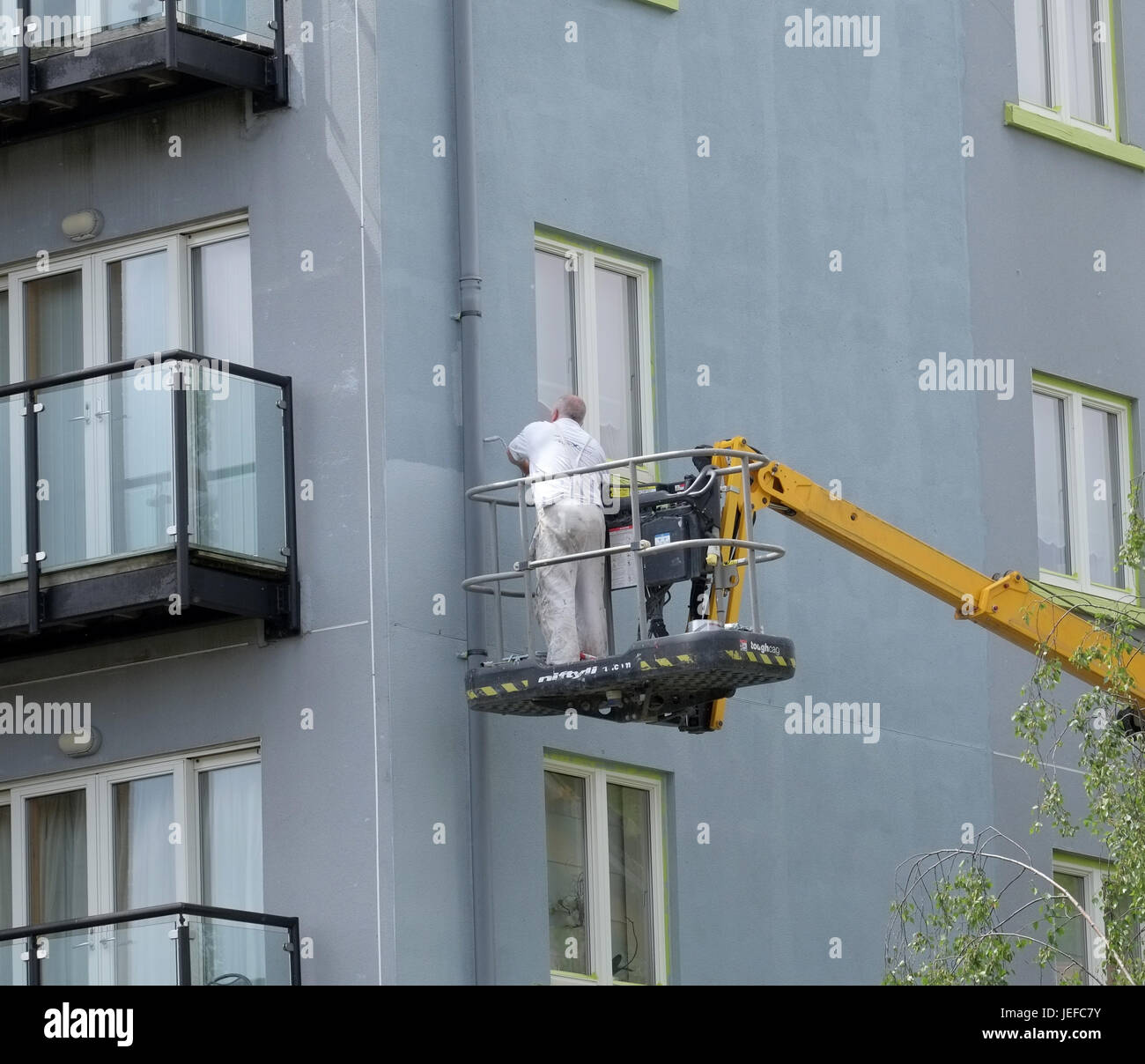 1 Giugno 2017 - vecchio pittore al lavoro sulla pittura il al di fuori della zona residenziale di appartamenti in Portishead Foto Stock