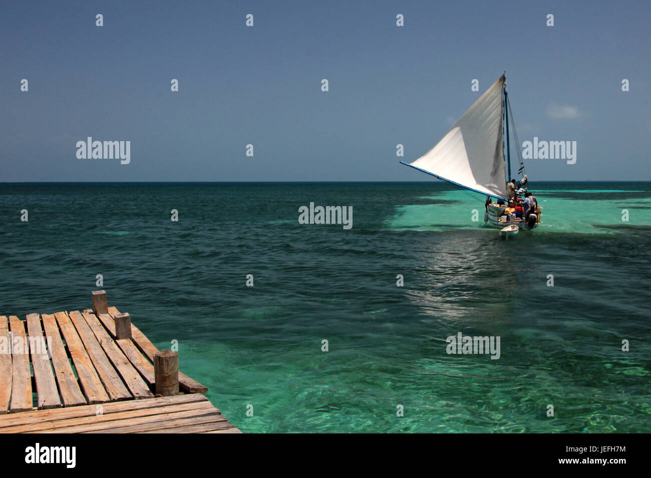 Il molo di legno e nave a vela, Tabacco Caye Belize Foto Stock