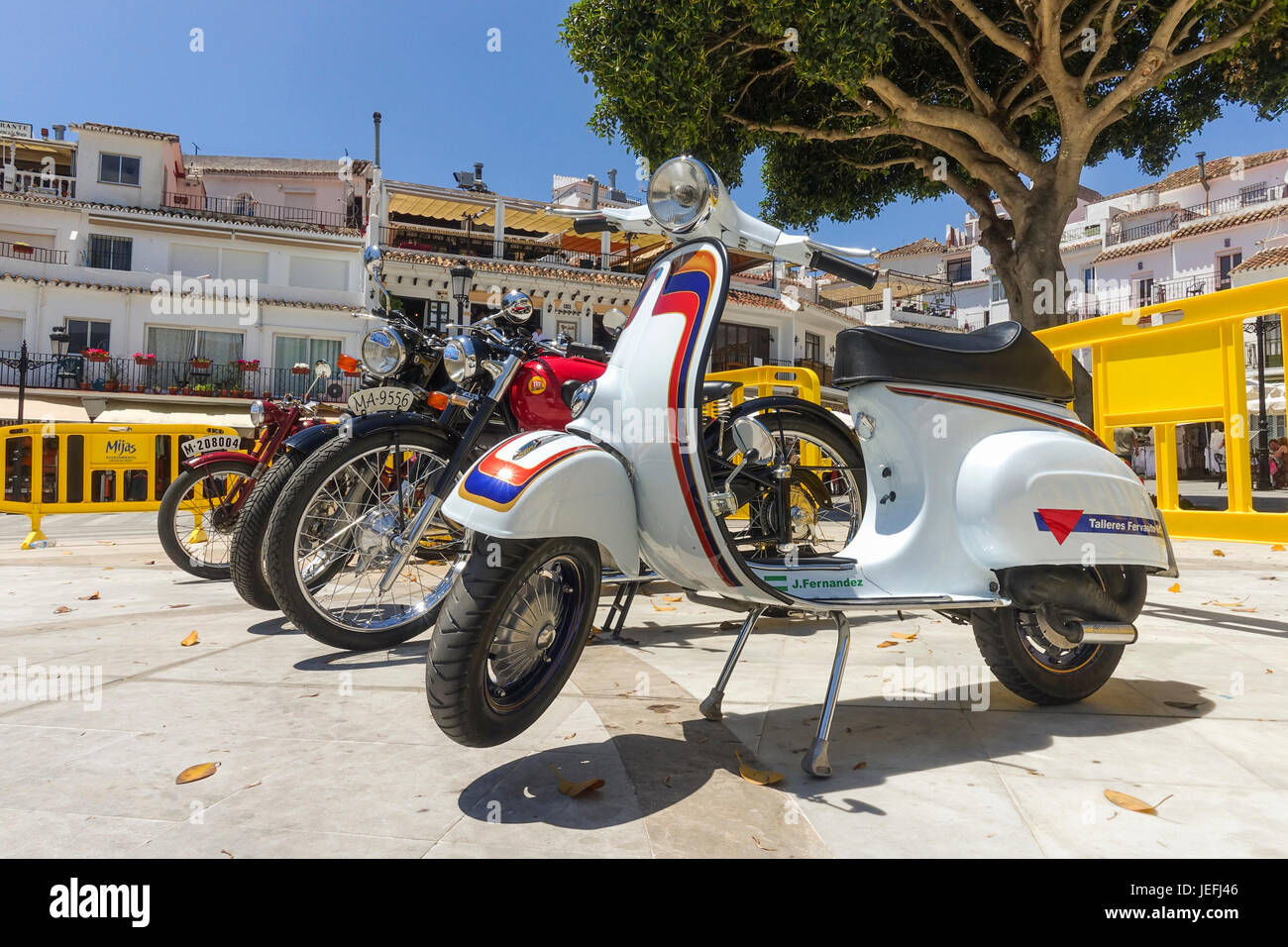 Fila di biciclette classiche con scooter Vespa davanti, sul visualizzatore in corrispondenza di una classica motocicletta incontro a Mijas, Andalusia, Spagna. Foto Stock