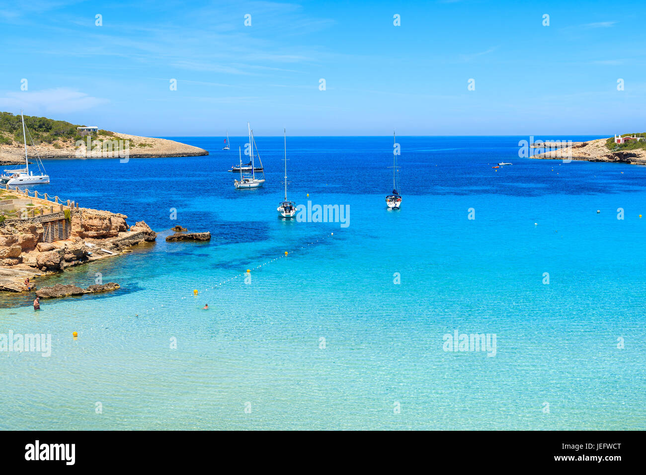 Barche a vela sul blu del mare a Cala Portinatx bay, isola di Ibiza, Spagna Foto Stock