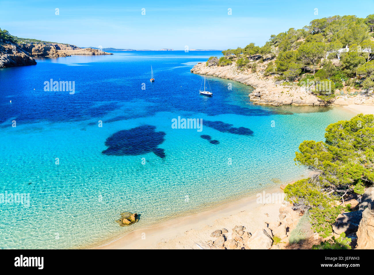 Vista della bellissima spiaggia di Cala Salada famoso per il suo azzurro mare cristallino acqua, isola di Ibiza, Spagna Foto Stock