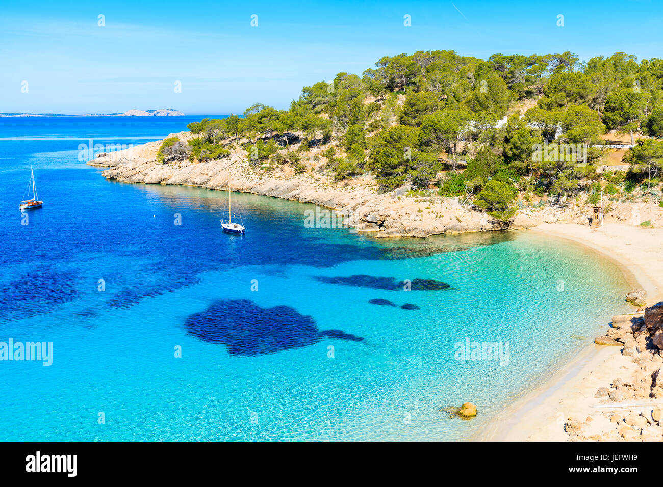 Vista della bellissima spiaggia di Cala Salada famoso per il suo azzurro mare cristallino acqua, isola di Ibiza, Spagna Foto Stock