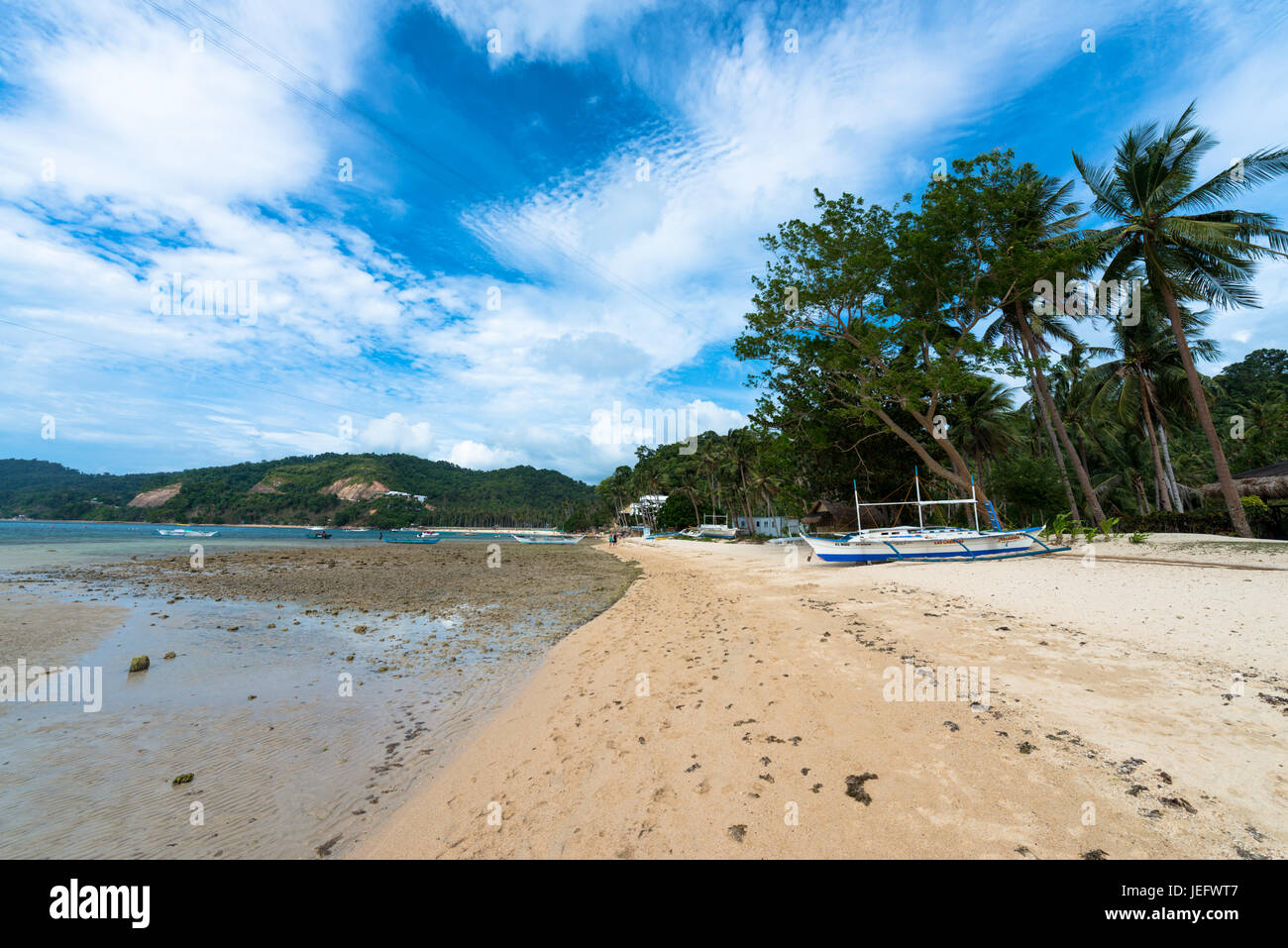 EL NIDO, PALAWAN FILIPPINE - MARZO 29, 2017: un ampio angolo di visione di Las cabanas sulla spiaggia con una barca e alcune palme. Foto Stock