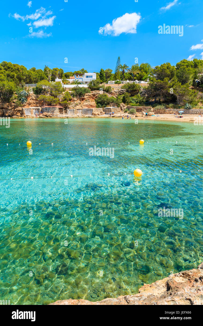 Turchesi acque cristalline della bella Spiaggia Cala Gracio, isola di Ibiza, Spagna Foto Stock