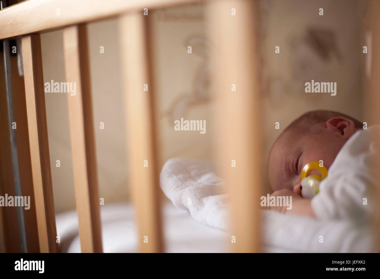 Neonato nel presepe con il capezzolo in bocca Foto Stock