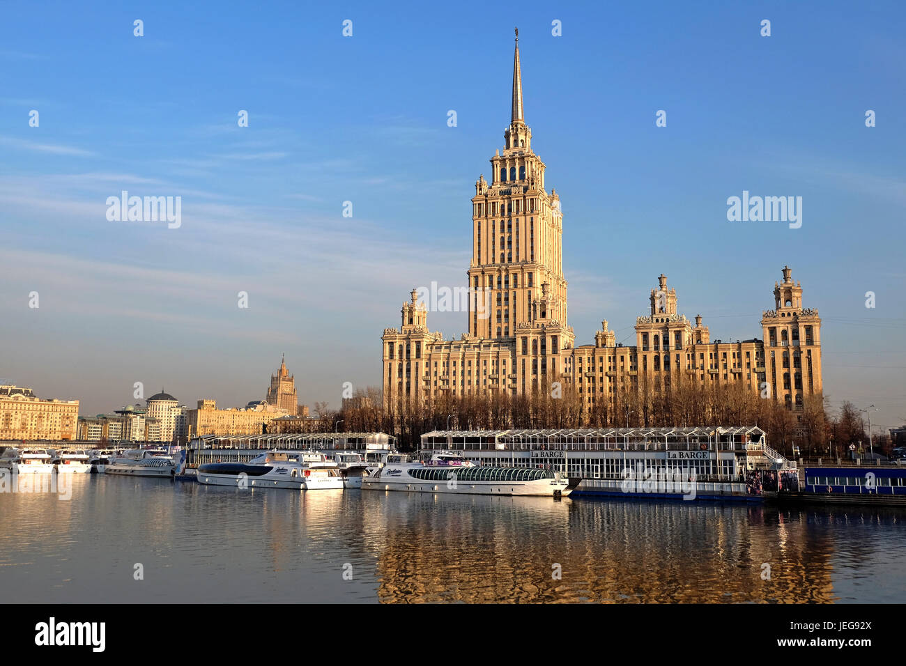Mosca, Russia - Agosto, 2016: Mosca fiume con un battello da crociera nella parte anteriore del grattacielo di Stalin - Hotel Ukraina del Radisson Hotel. Mosca, Russia. Foto Stock