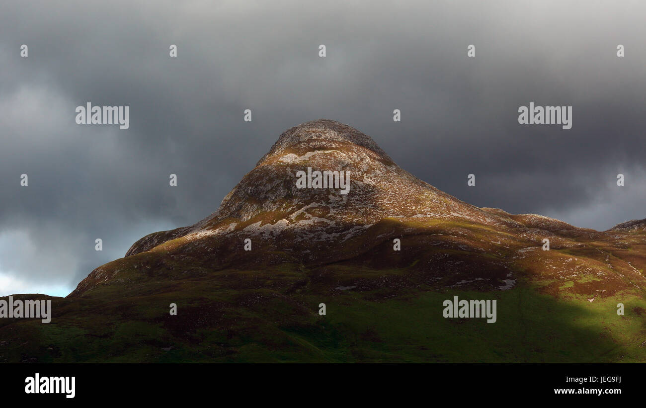Close-up, teleobiettivo, della stupefacente Pap di Glencoe da Ballachulish, Glencoe, Scozia su un giorno nuvoloso con il sole che illumina il picco Foto Stock