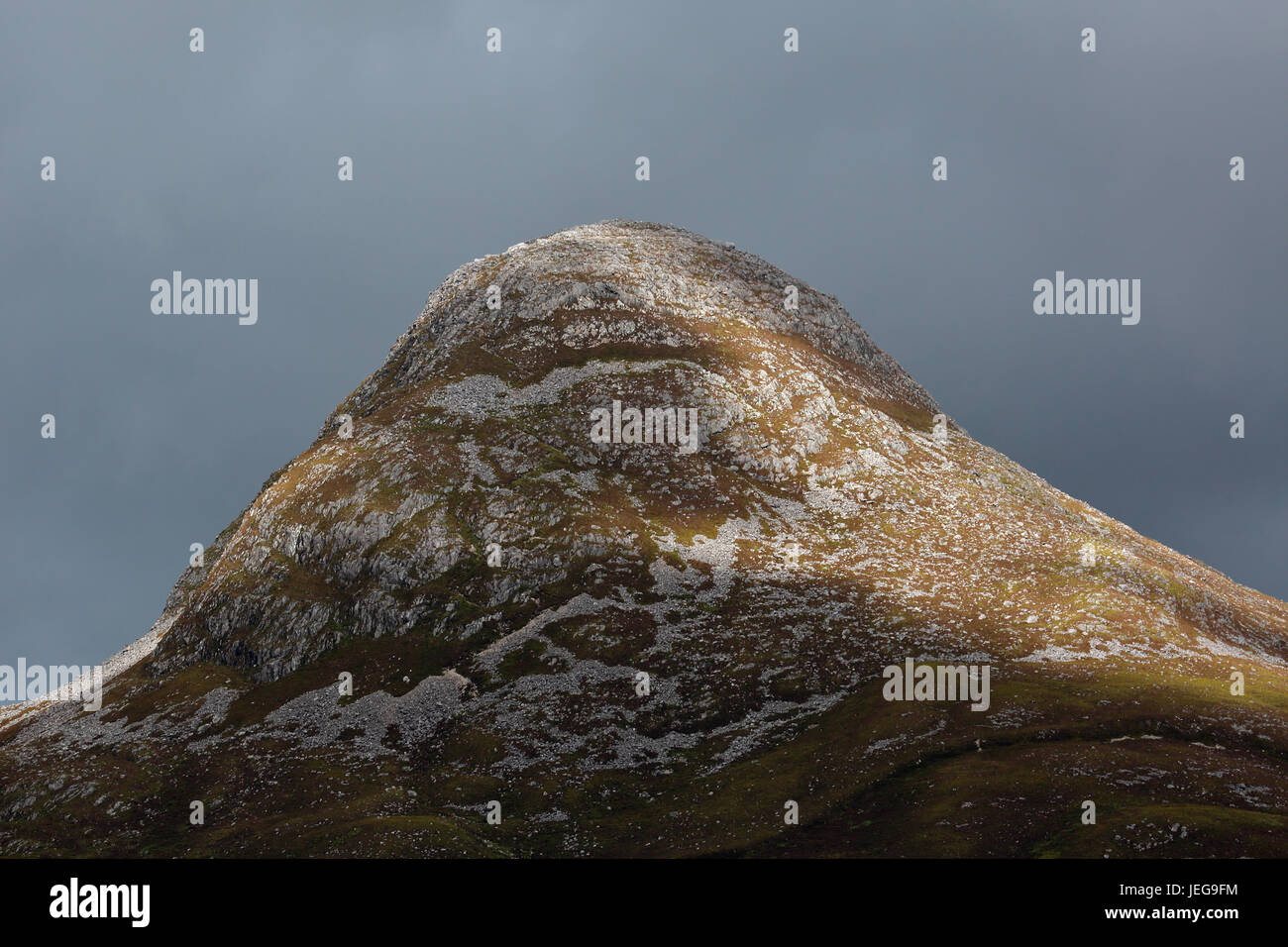 Close-up, teleobiettivo, della stupefacente Pap di Glencoe da Ballachulish, Glencoe, Scozia su un giorno nuvoloso con il sole che illumina il picco Foto Stock