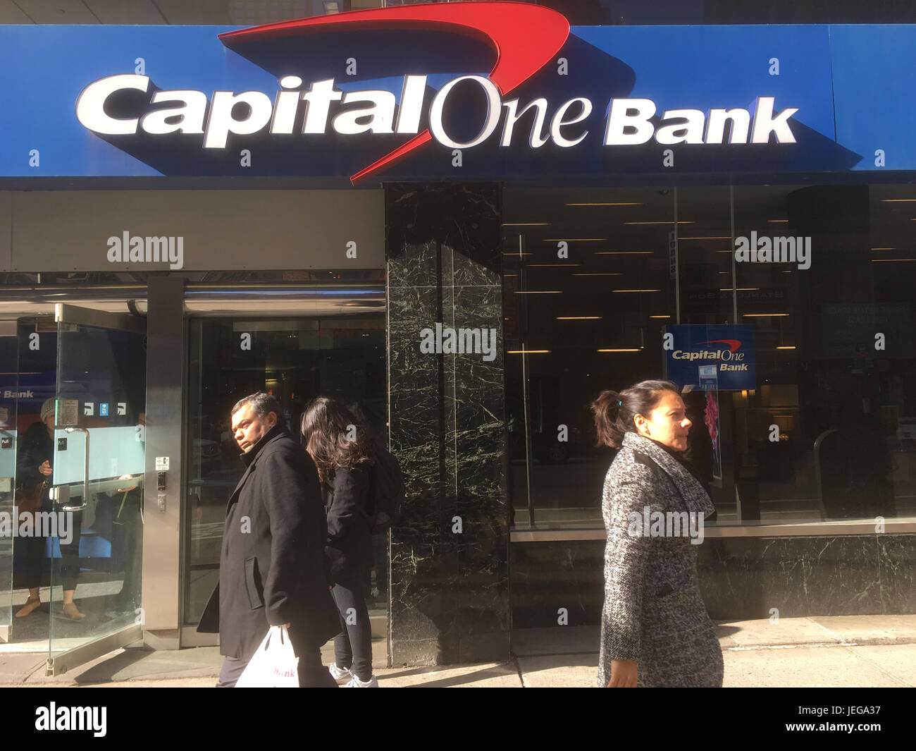 New York City - 28 Gennaio 2017: Tre persone passano il Midtown Manhattan capitale una banca sulla 6th Avenue in New York City. Esterno della capitale una b Foto Stock