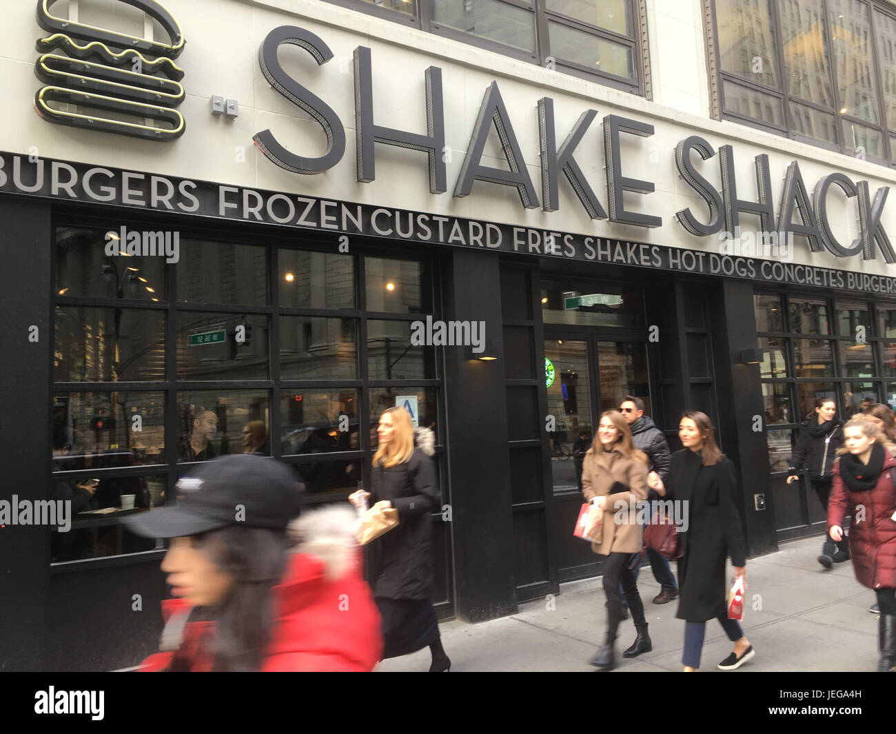1 febbraio 2017 - New York City: Persone che passano un Shake Shack nel centro di Manhattan in un pomeriggio soleggiato durante l'ora di pranzo. Freddo giorno invernale a New York. Foto Stock