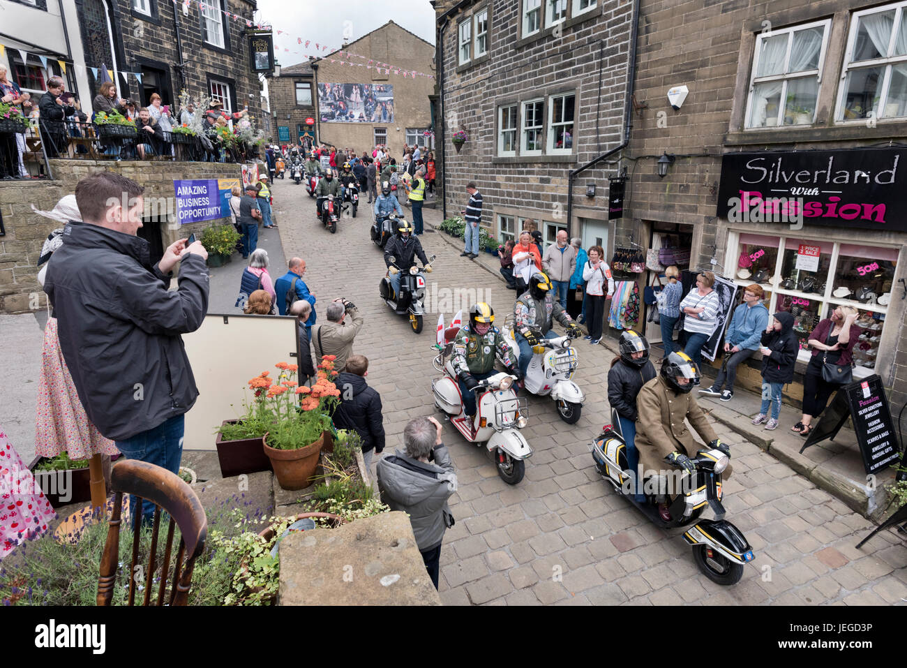 Haworth, West Yorkshire, Regno Unito. 24 GIU, 2017. Anni sessanta nel weekend il Bronte villaggio di Haworth, West Yorkshire. Sfilata di mods su scooter giù per la strada principale. Credito: John Bentley/Alamy Live News Foto Stock