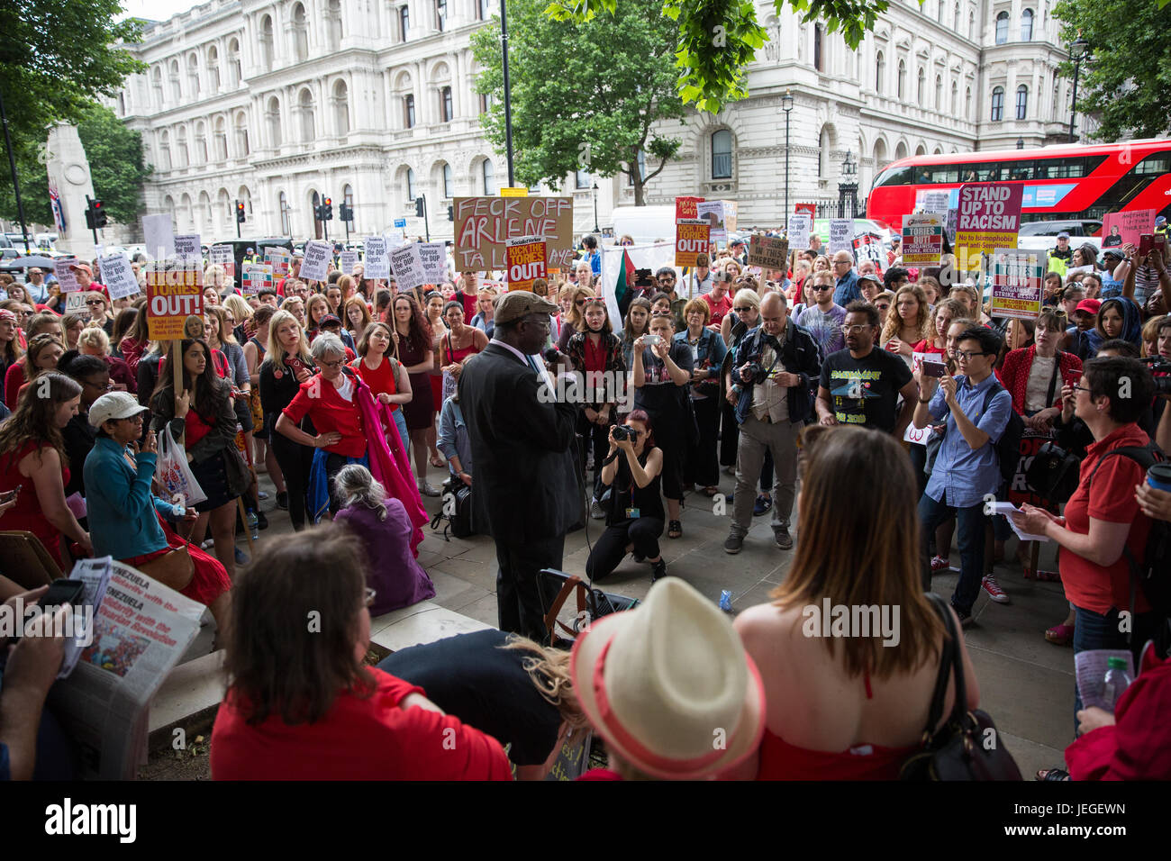 Londra, Regno Unito. Il 24 giugno 2017. Un uomo che rappresenta la comunità del Grenfell indirizzi Torre donne, molti di chi indossa il rosso, che protestavano davanti a Downing Street contro qualsiasi accordo tra il partito conservatore e il democratico partito unionista (DUP). La donna ha parlato contro la DUP sulle restrizioni sui diritti delle donne e delle persone LGBT e collegamenti a lontano- diritto politica e anche nel supporto di destra per accedere all'aborto in Irlanda del Nord. Credito: Mark Kerrison/Alamy Live News Foto Stock