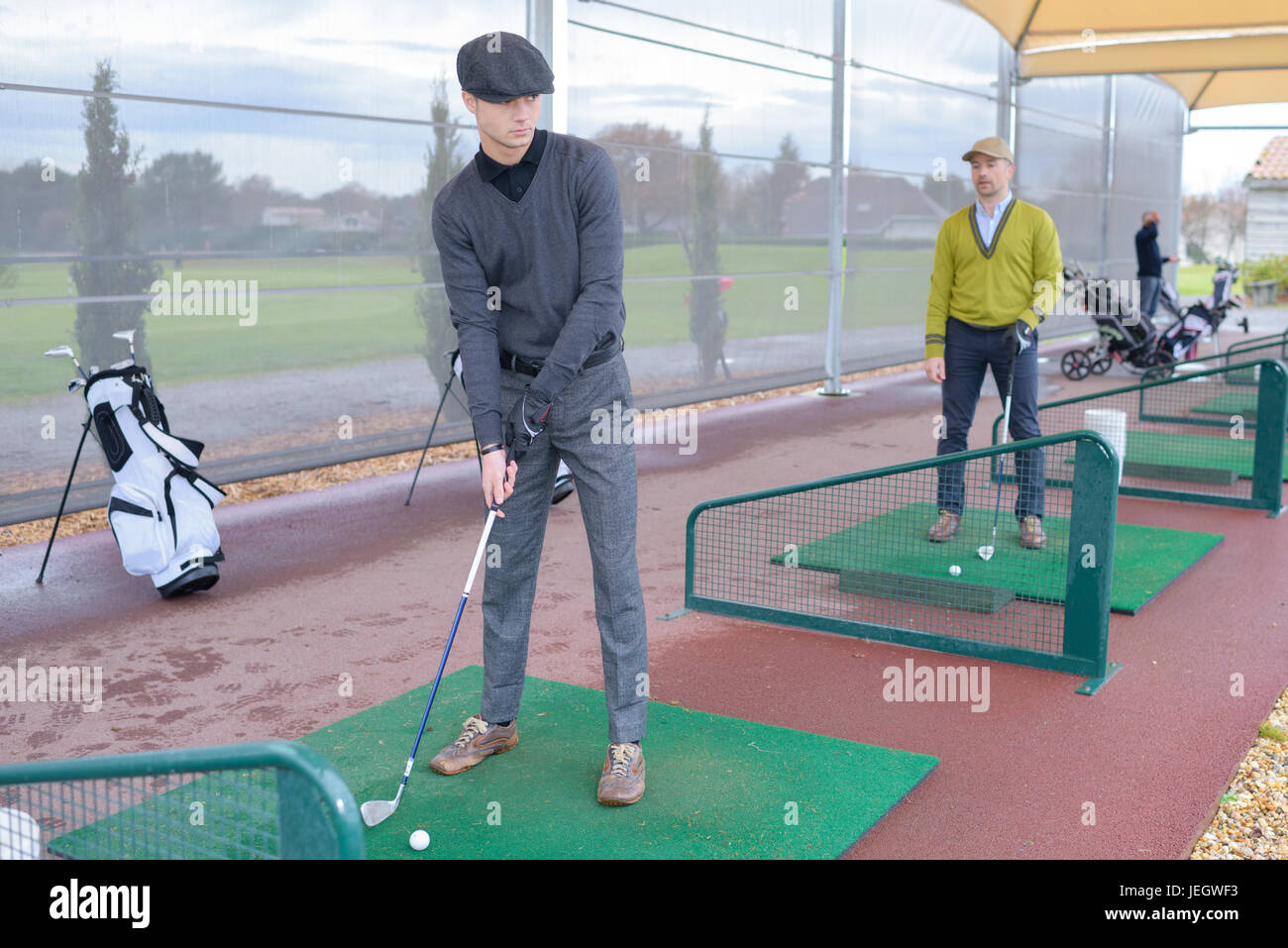 Persone praticare il golf presso un centro golf driving range Foto Stock