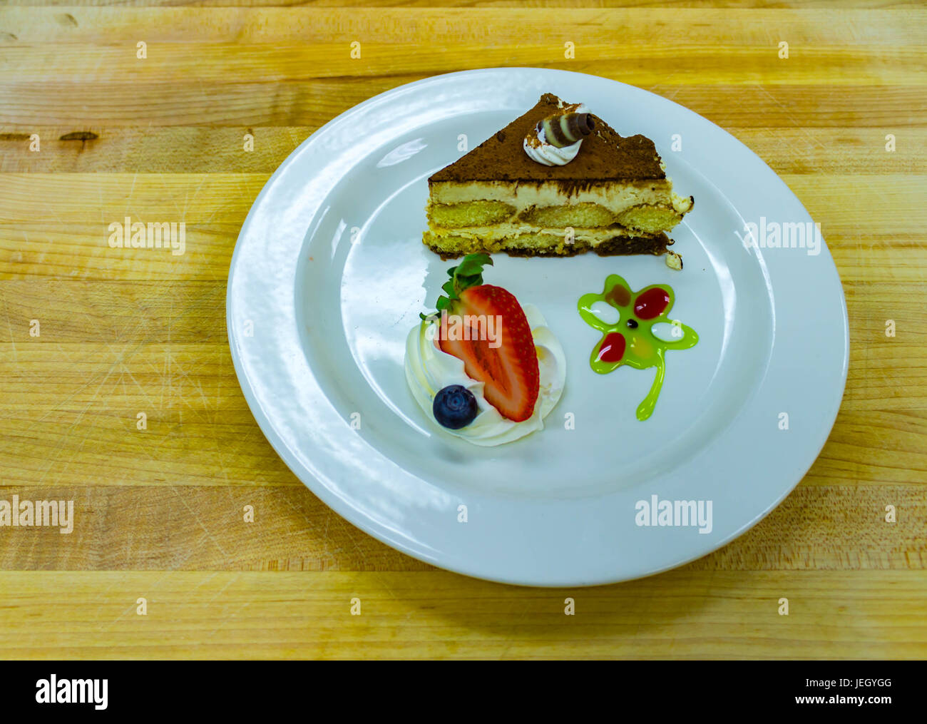 Il tiramisù dessert su piastra bianca con frutta Foto Stock
