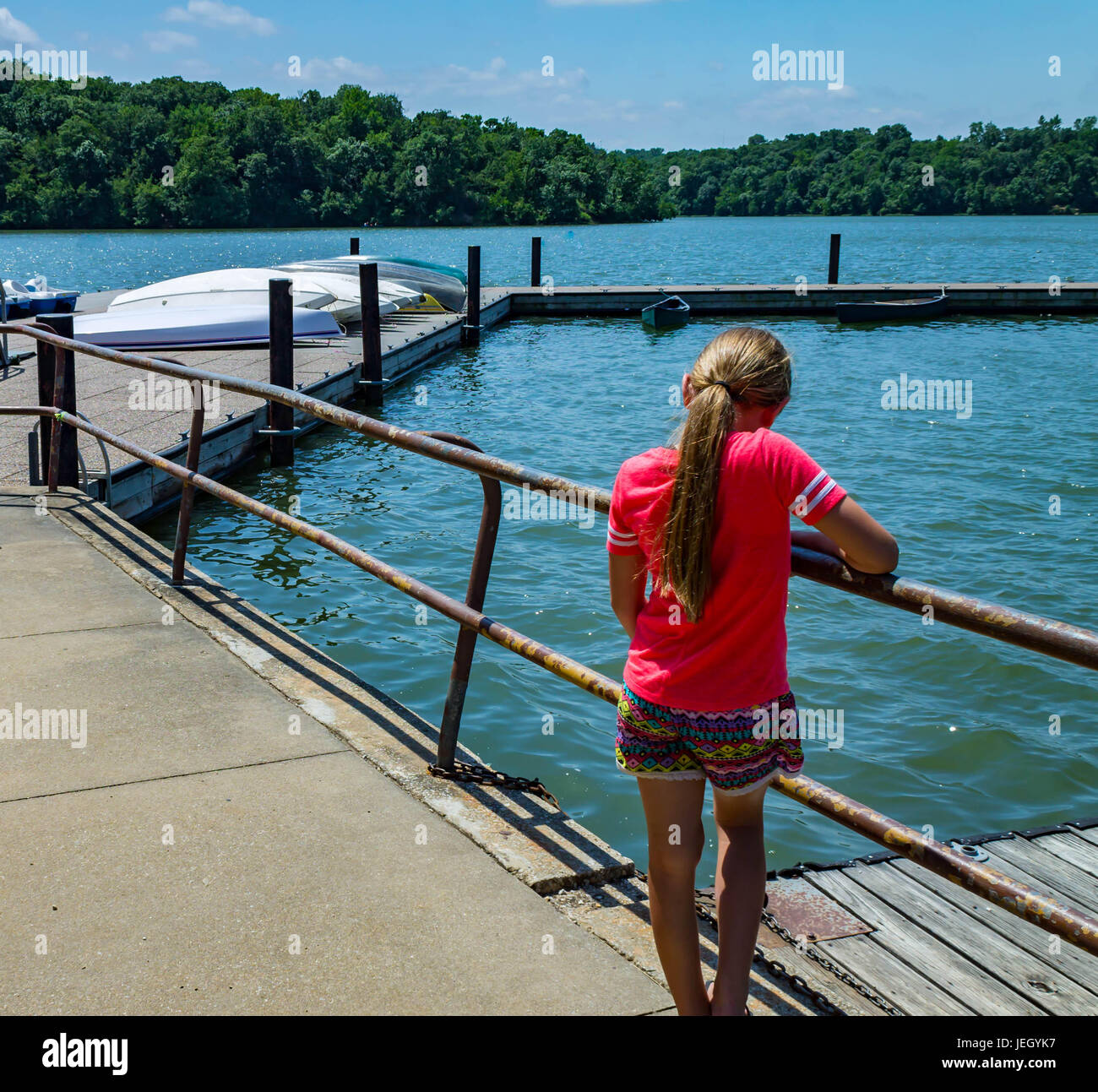 Bambina guardando in giù nel lago Foto Stock