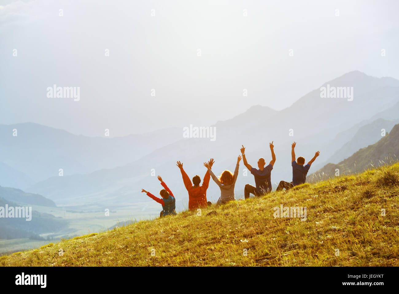 Gruppo happy amici montagne al tramonto Foto Stock