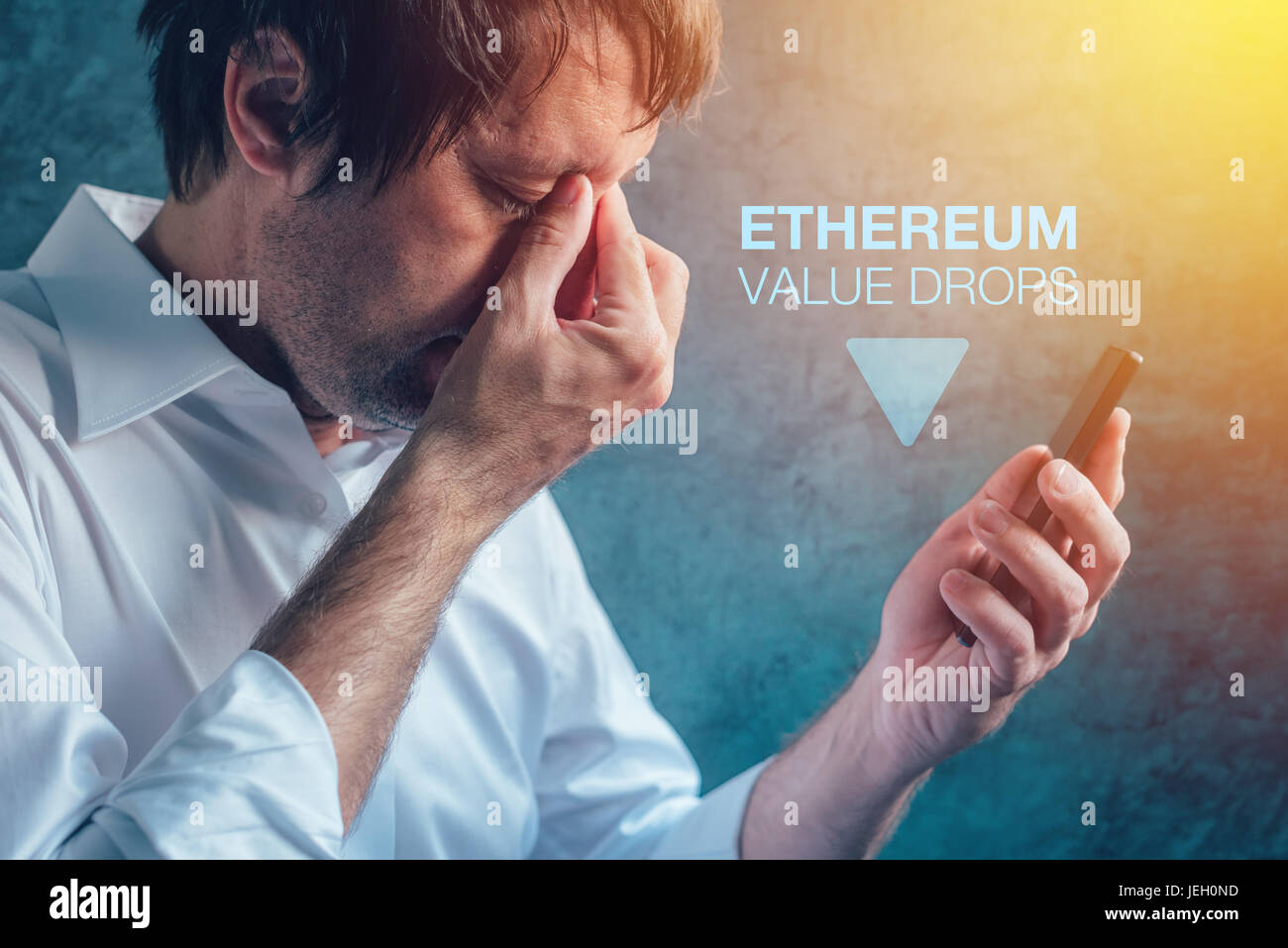 Ethereum cryptocurrency valore scende nozione di imprenditore maschio e uno smartphone Foto Stock