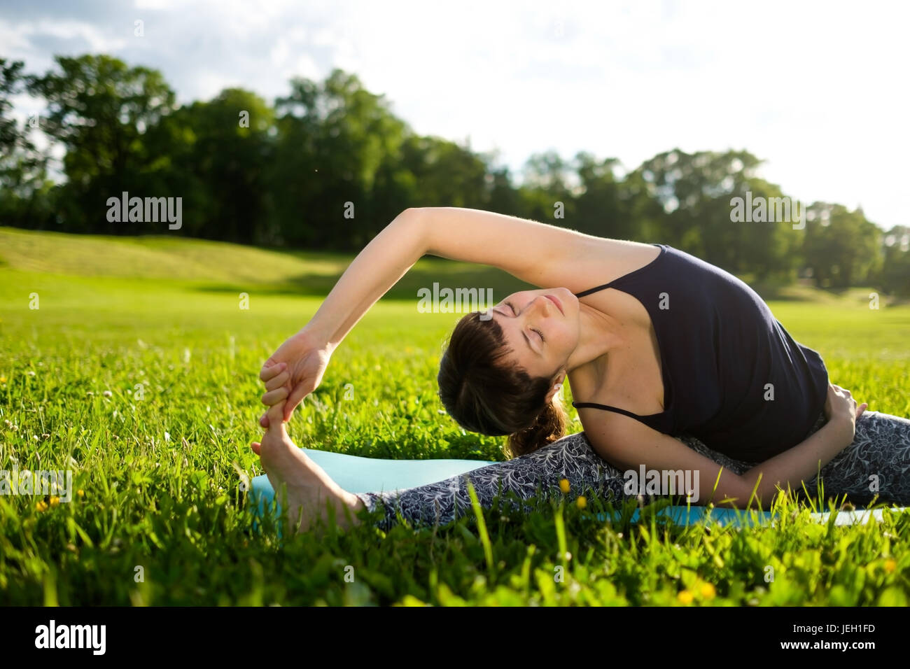 La donna le pratiche yoga asana in parco nella mattina. Foto Stock