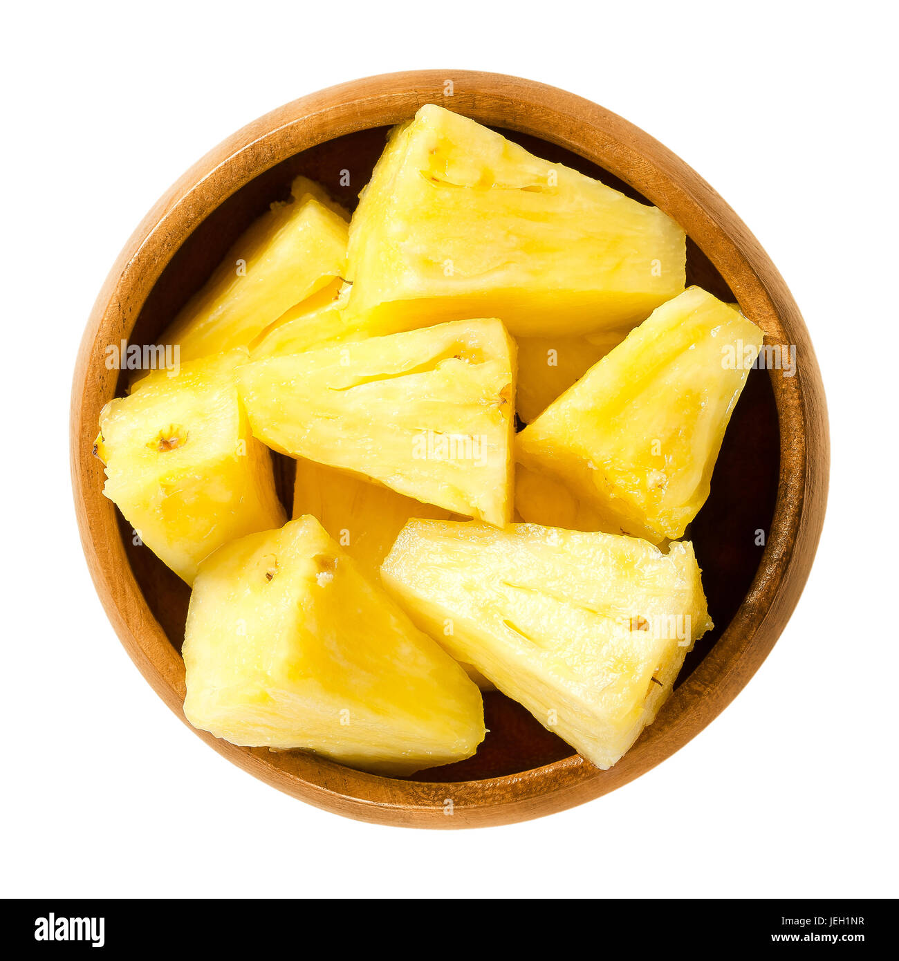 Pezzi di ananas in ciotola di legno. Ananas comosus, prodotti commestibili più frutto di una pianta tropicale, costituito da bacche coalescente. Polpa di colore giallo. Foto. Foto Stock